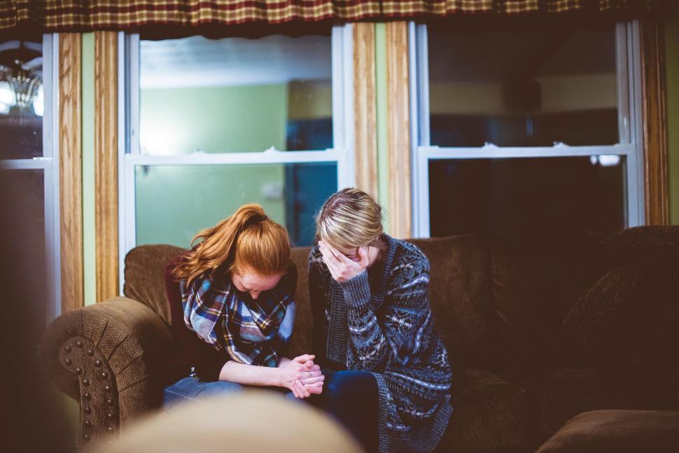 Free Image of Two Women Sitting on Top of a Couch 