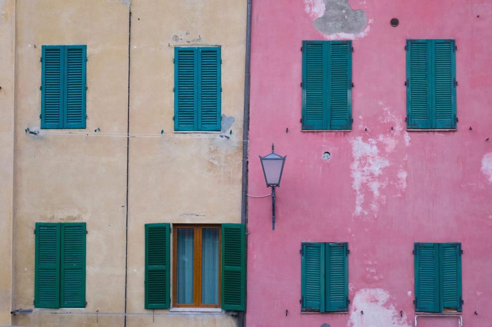 Free Image of Pink Building With Green Shutters and Red Fire Hydrant 