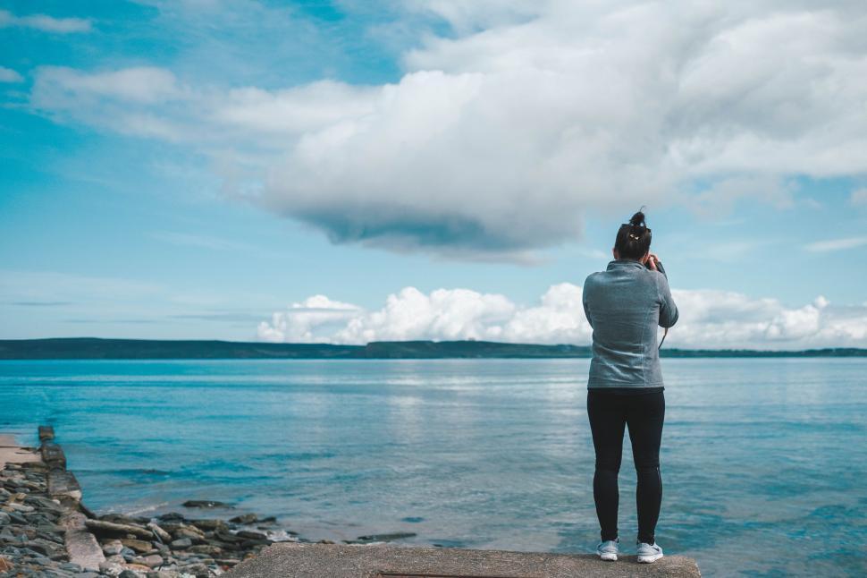 Free Image of Person Standing on Rock Looking Out at Water 