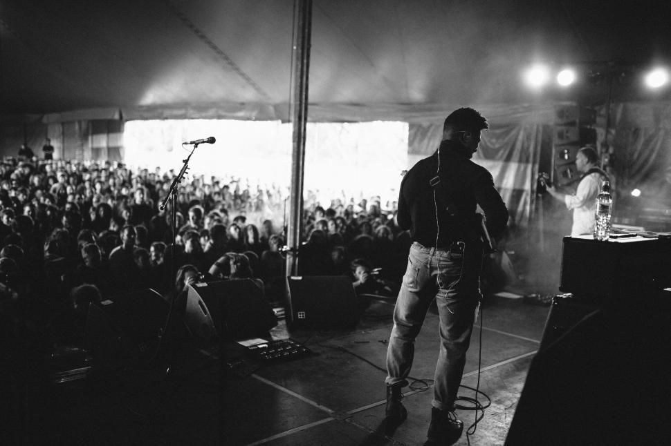 Free Image of Man Standing in Front of Microphone on Stage 