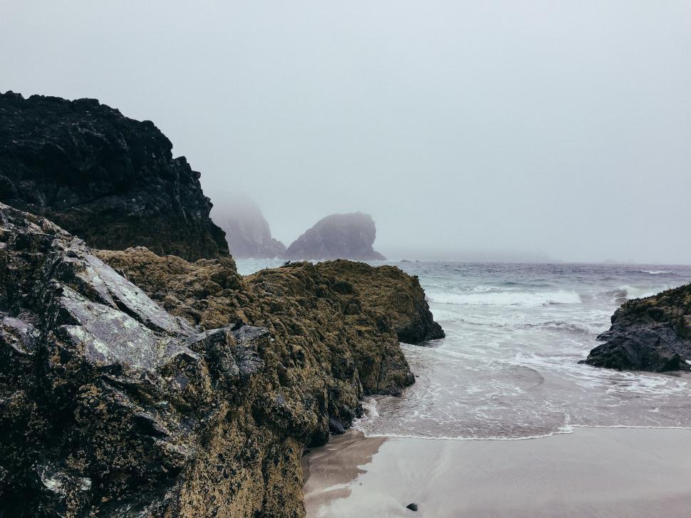 Free Image of Person Walking on Beach Next to Ocean 