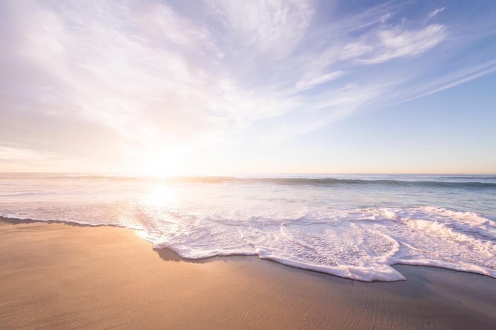 Free Image of Sun Setting Over Ocean on Beach 