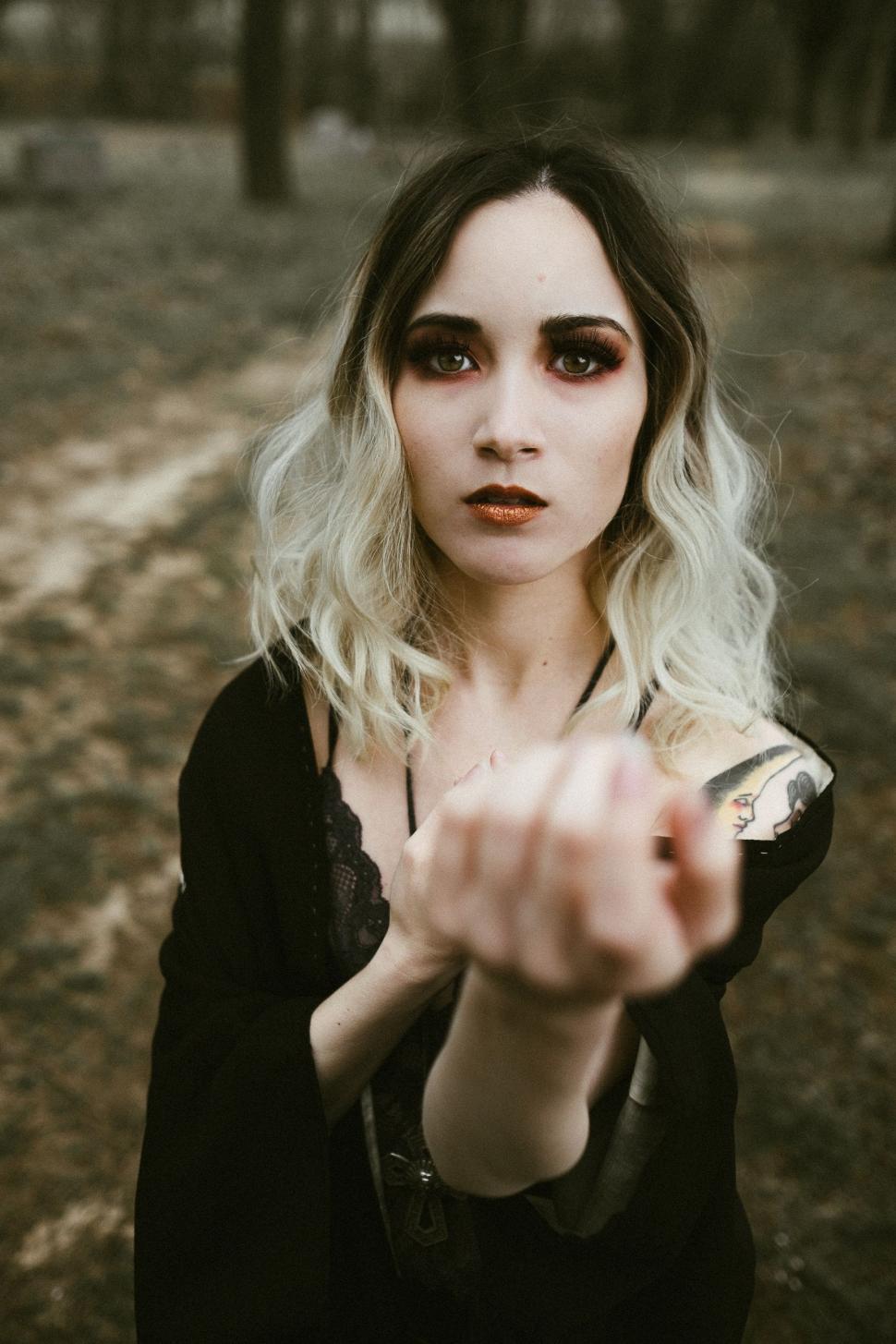 Free Image of Woman With Long Hair Pointing at the Camera 