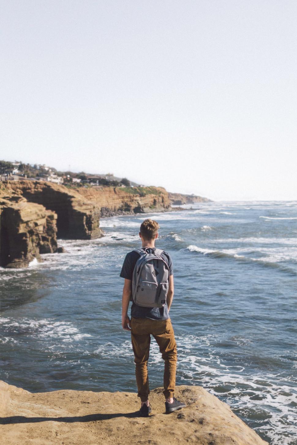 Free Image of Man Standing on Cliff Overlooking Ocean 