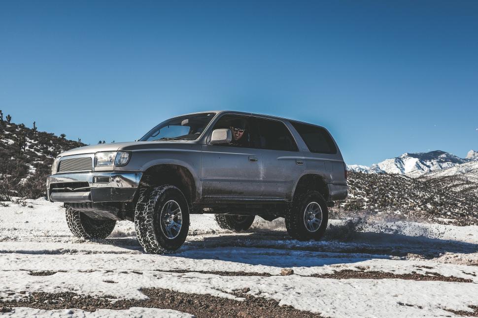 Free Image of Silver Truck Driving Through Snow-Covered Field 