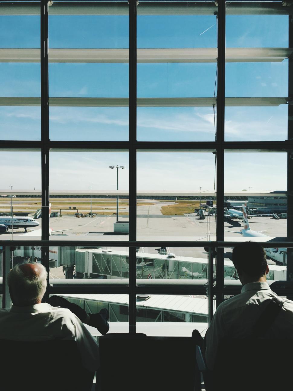 Free Image of Two Men Sitting in Front of a Window 