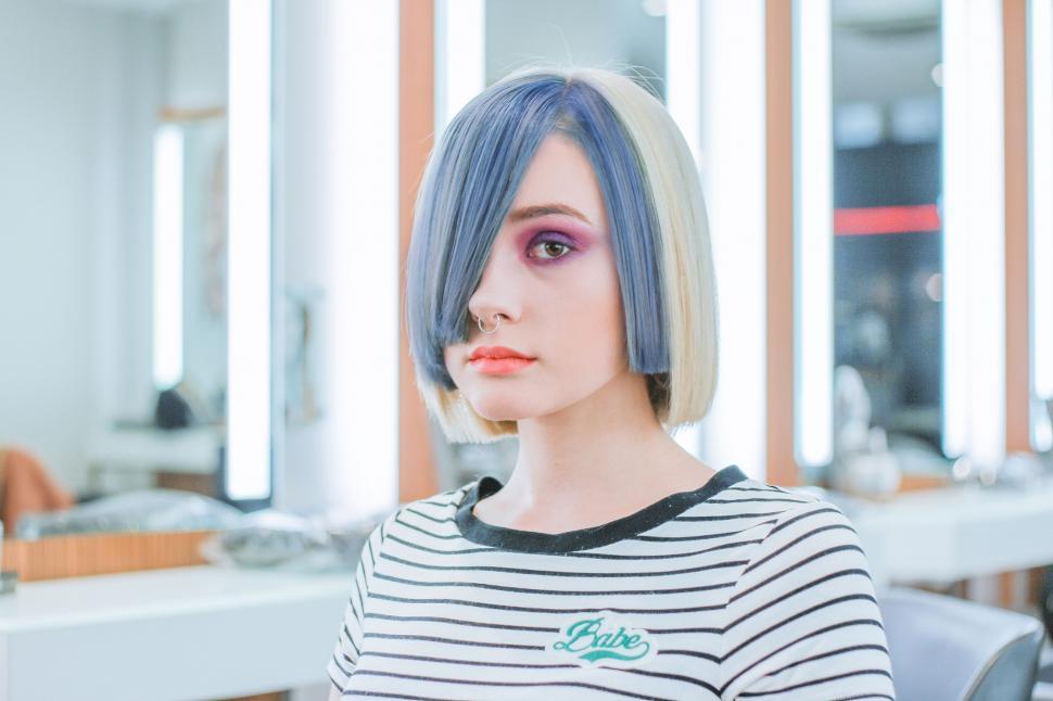 Free Image of Woman With Blue Hair Sitting in Front of Mirror 