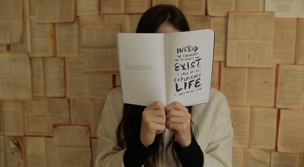 Free Image of Woman Holding Book Up to Face 