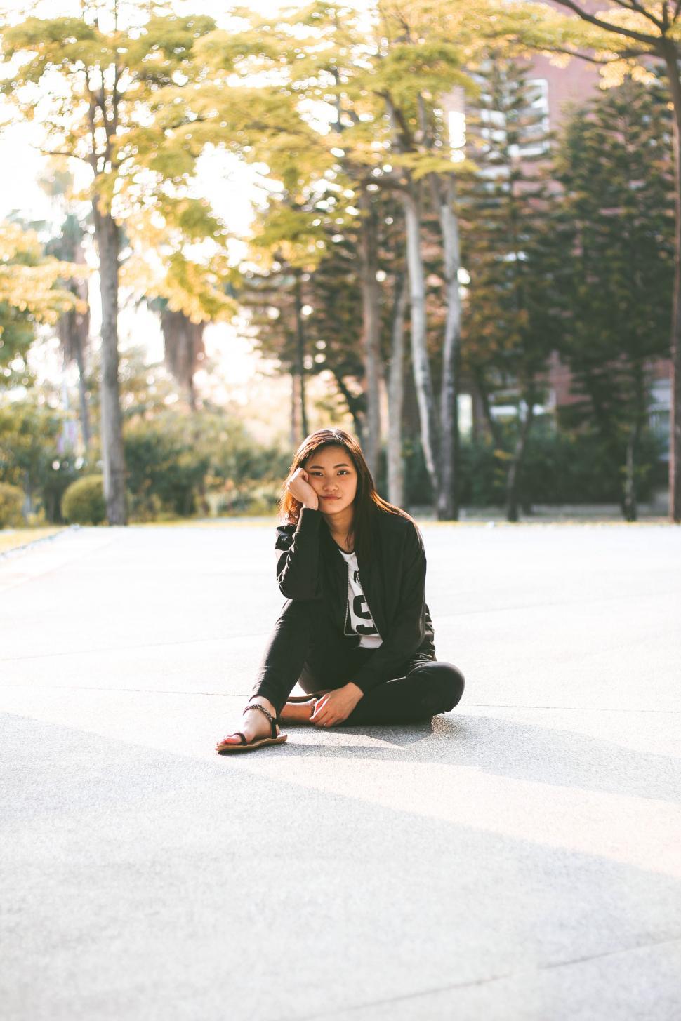 Free Image of Woman Sitting on Ground Talking on Cell Phone 