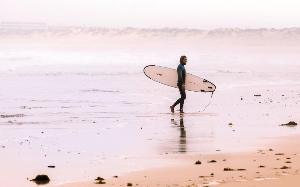 Free Image of Person Walking on Beach With Surfboard 