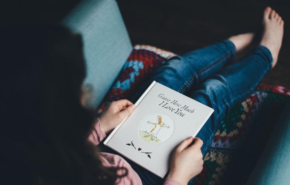 Free Image of Person Reading Book on Couch 