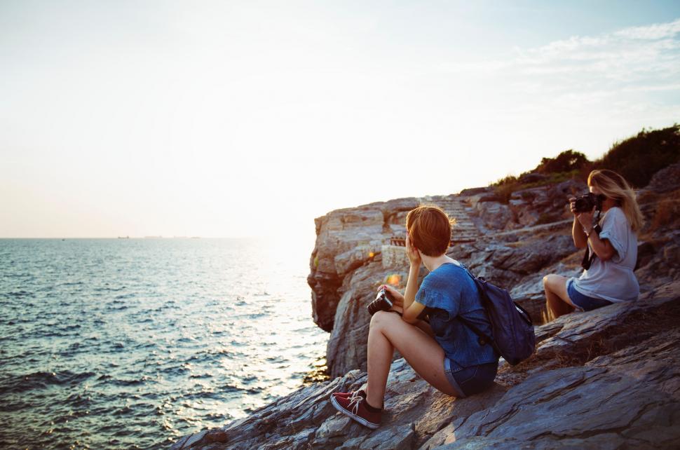 Free Image of People Sitting on Rock by Ocean 