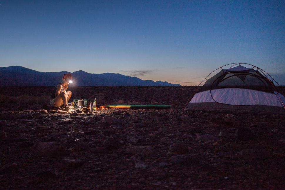 Free Image of Person Sitting Next to Tent in Desert 