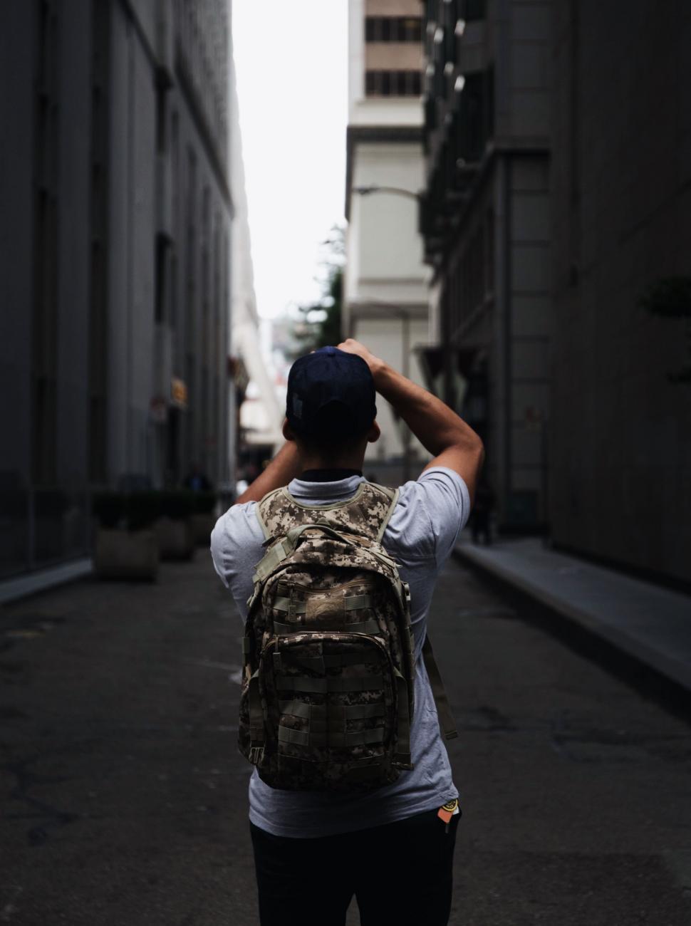 Free Image of Person Walking Down a Street With Backpack 