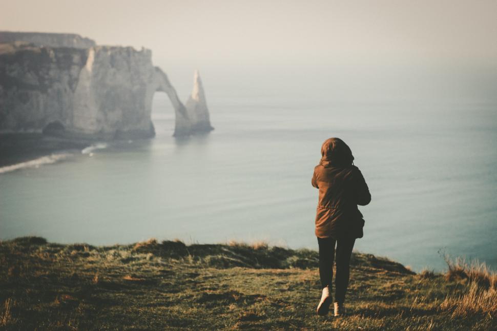 Free Image of Person Standing on Hill Overlooking Body of Water 