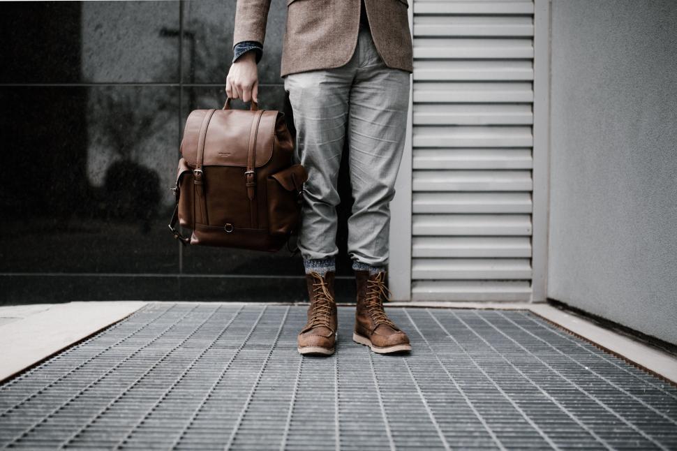 Free Image of Businessman in Suit and Tie Holding Brown Bag 