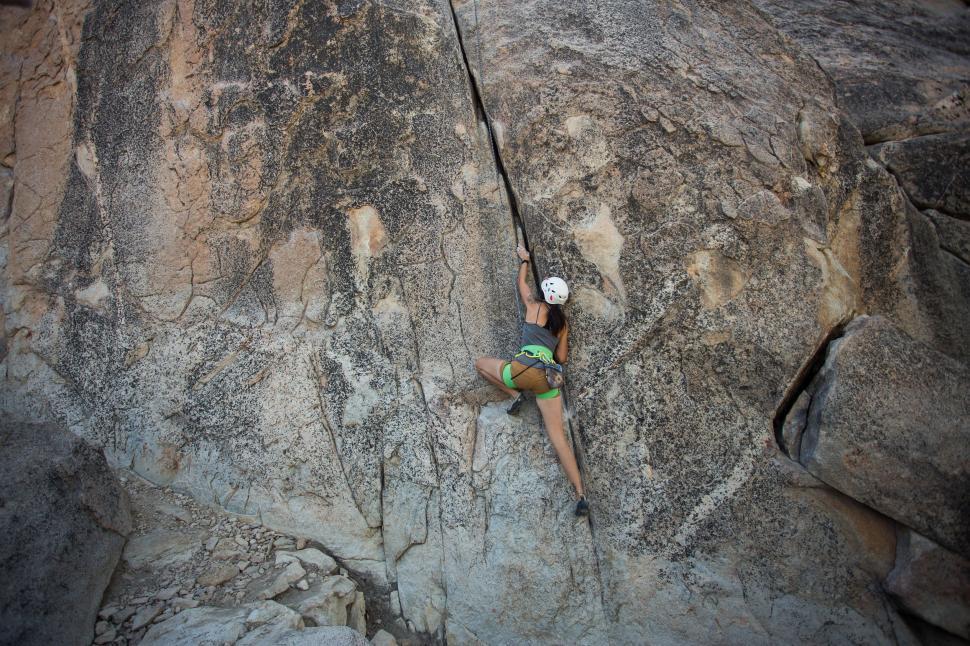 Free Image of Man Climbing Up the Side of a Mountain 