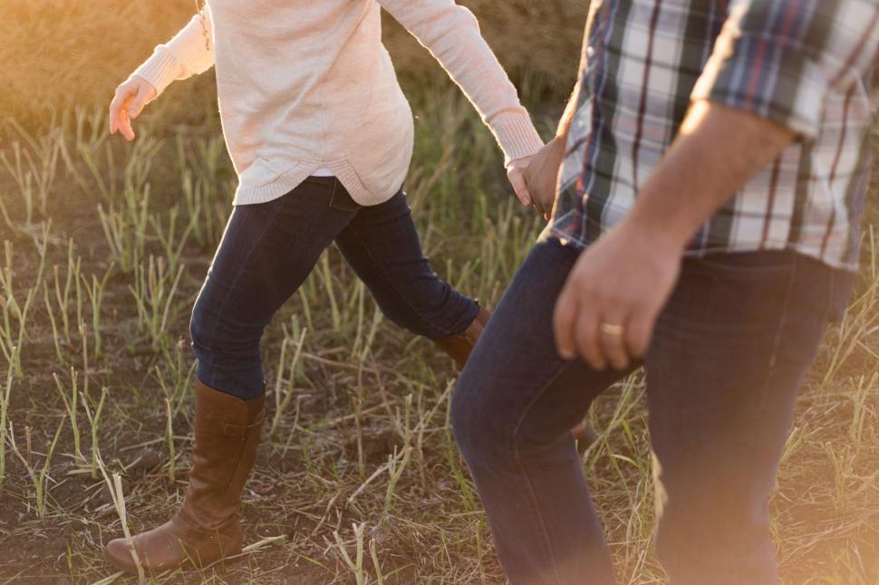 Free Image of A Man and a Woman Walking Through a Field 