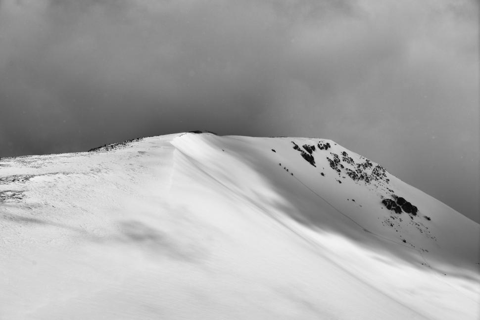 Free Image of Man Snowboarding Down Snow-Covered Slope 