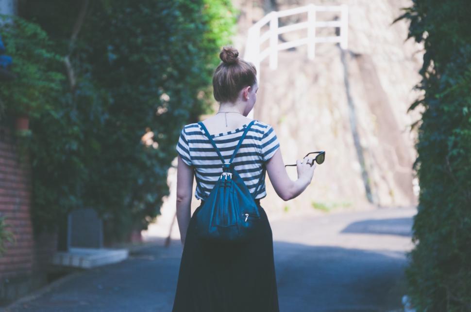 Free Image of Woman Walking Down Street Holding Cell Phone 