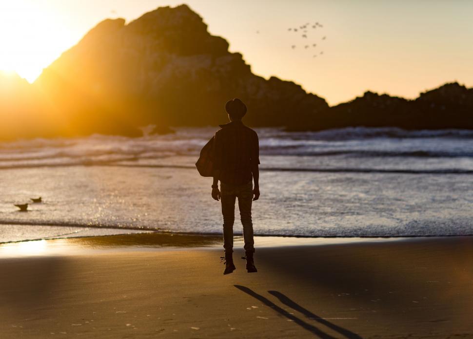 Free Image of Person Standing on Beach With Surfboard 