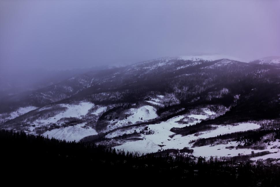 Free Image of Snow Covered Mountain With Snowboarder in Foreground 