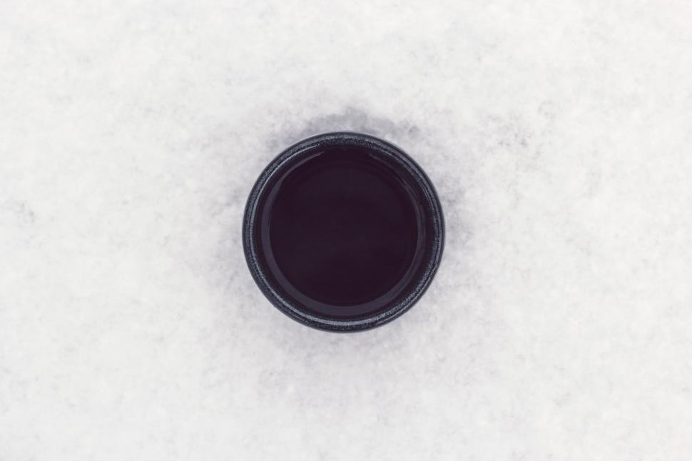 Free Image of Black Cup Resting on Snow Covered Ground 