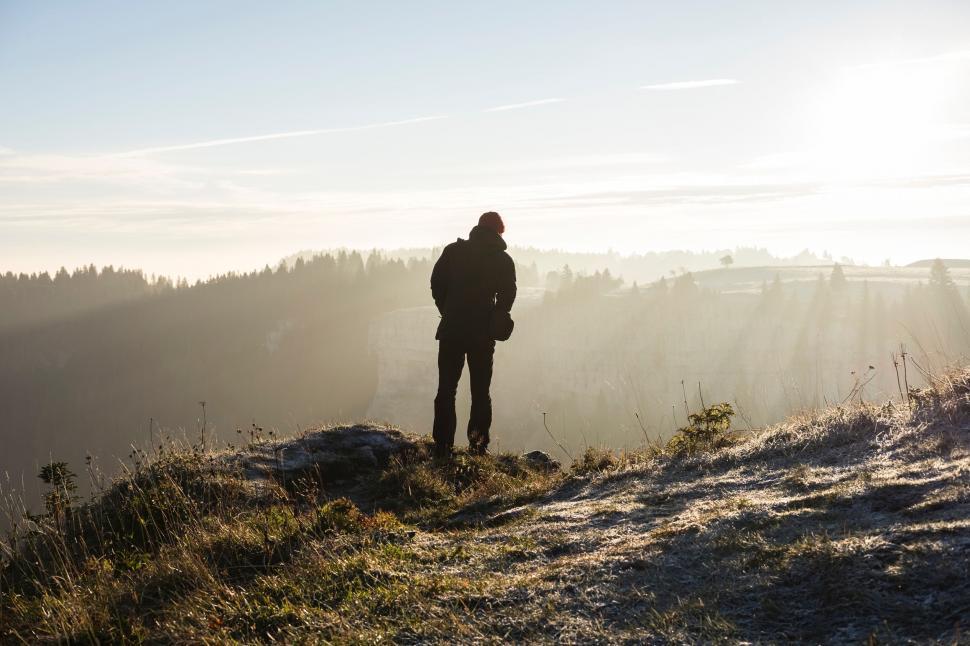 Free Image of Man Standing on Top of Snow Covered Hill 