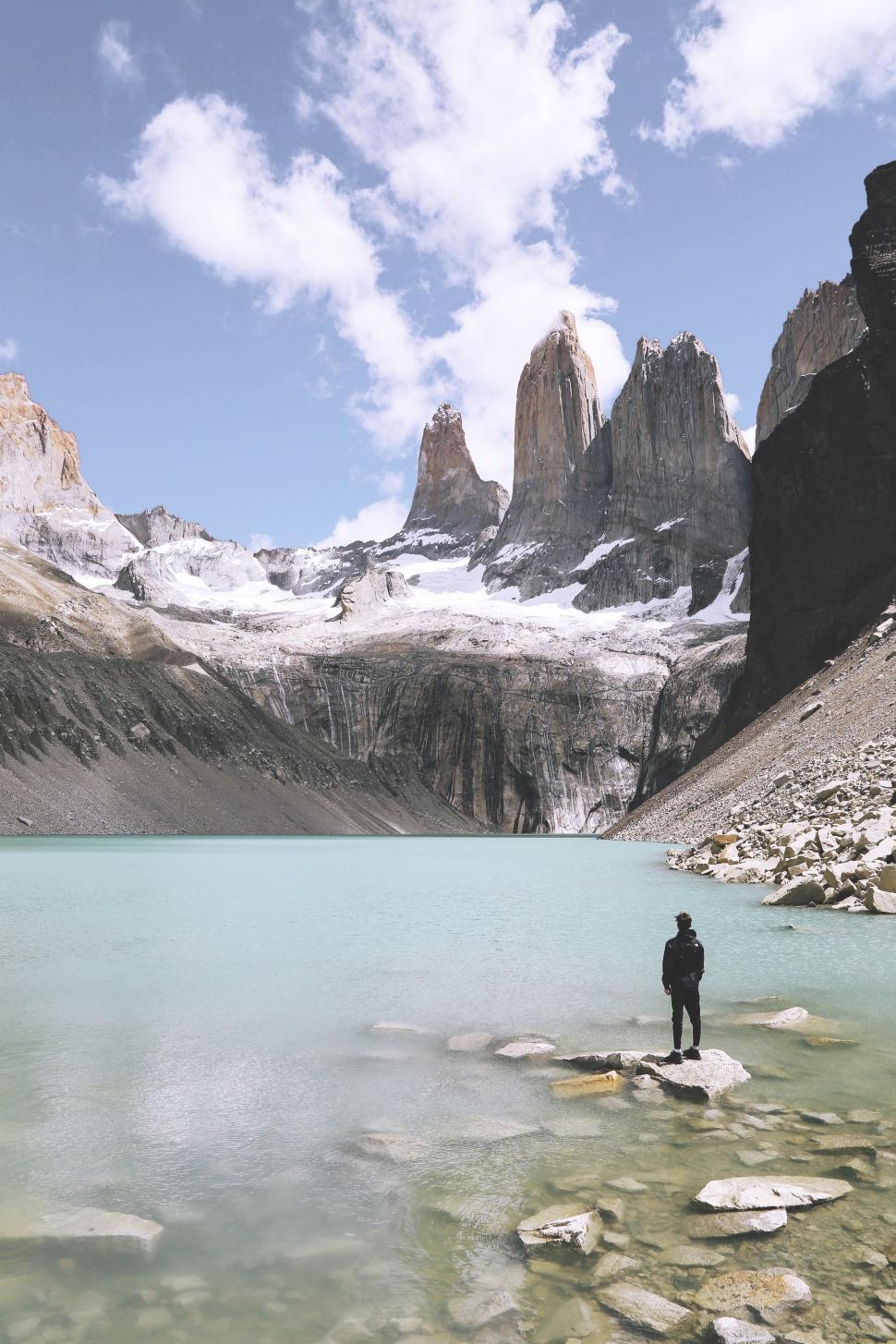 Free Image of Man Standing on Rock in Front of Mountain Lake 