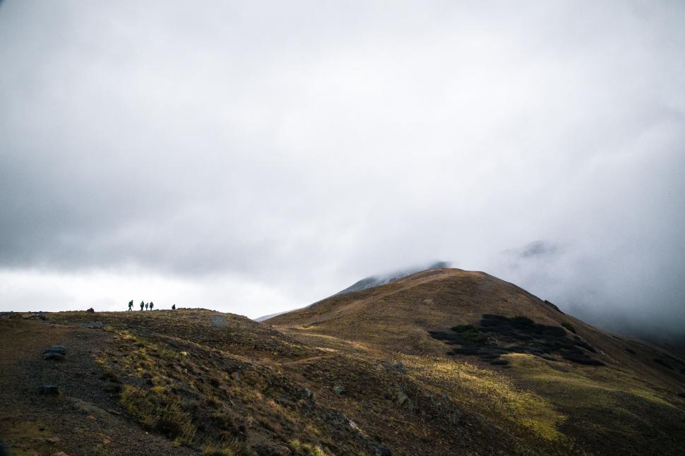 Free Image of Group of People Standing on Top of a Mountain 