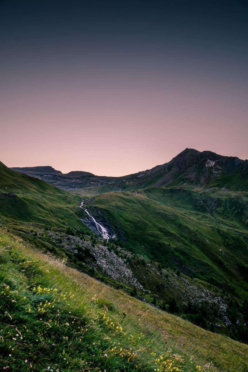 Free Image of Grassy Hill With River Running Through It 