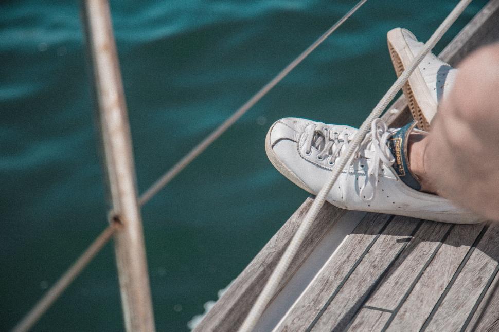 Free Image of Persons Feet on Wooden Dock by Water 