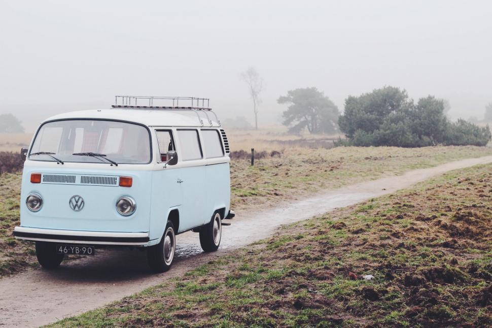 Free Image of VW Bus Driving Down Dirt Road 