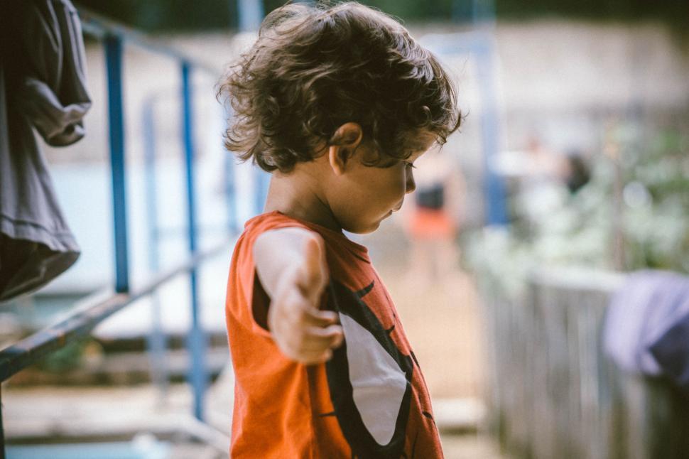Free Image of Young Boy Pointing at Something in the Distance 