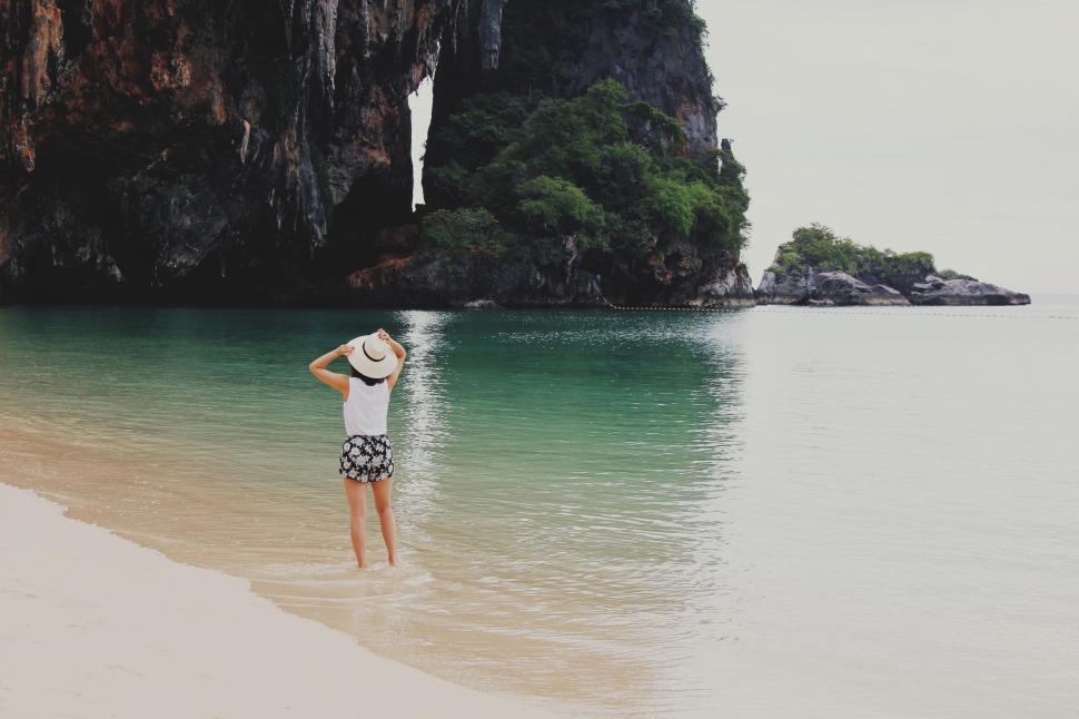 Free Image of Person Standing on Beach With Hat On 