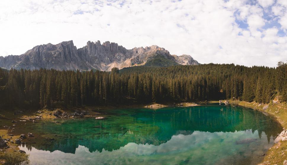 Free Image of Lake Surrounded by Trees and Mountains Under a Cloudy Sky 