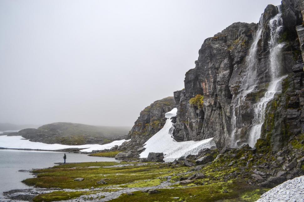Free Image of Man Standing in Front of Waterfall 
