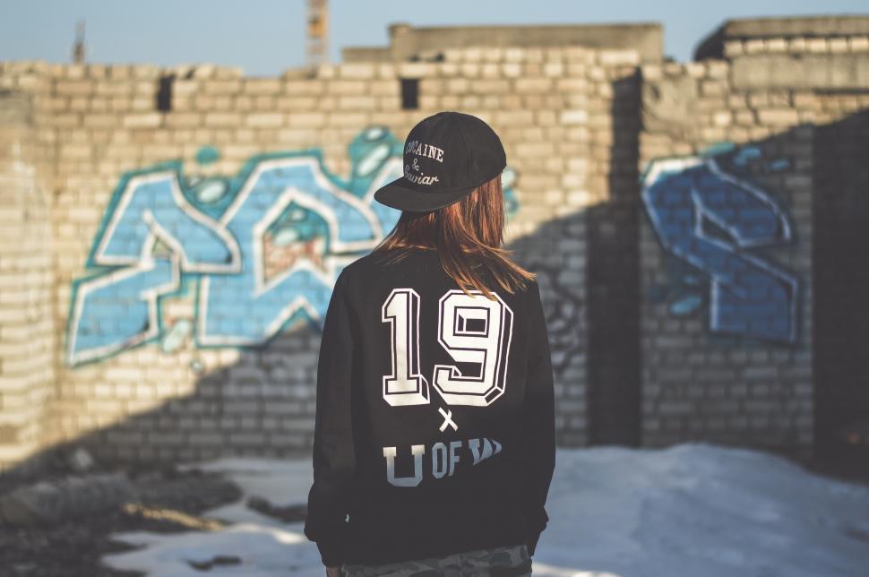 Free Image of Person Standing in Front of Graffiti Covered Wall 
