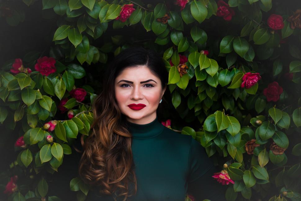 Free Image of Woman Standing in Front of Flower Bush 