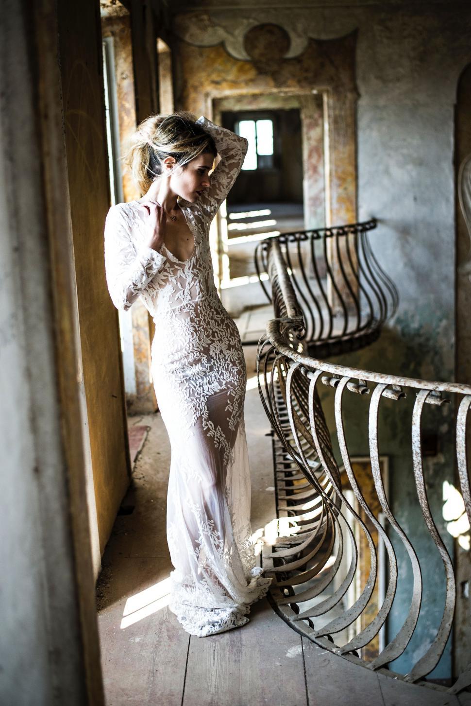 Free Image of Woman in White Dress Standing in Room 