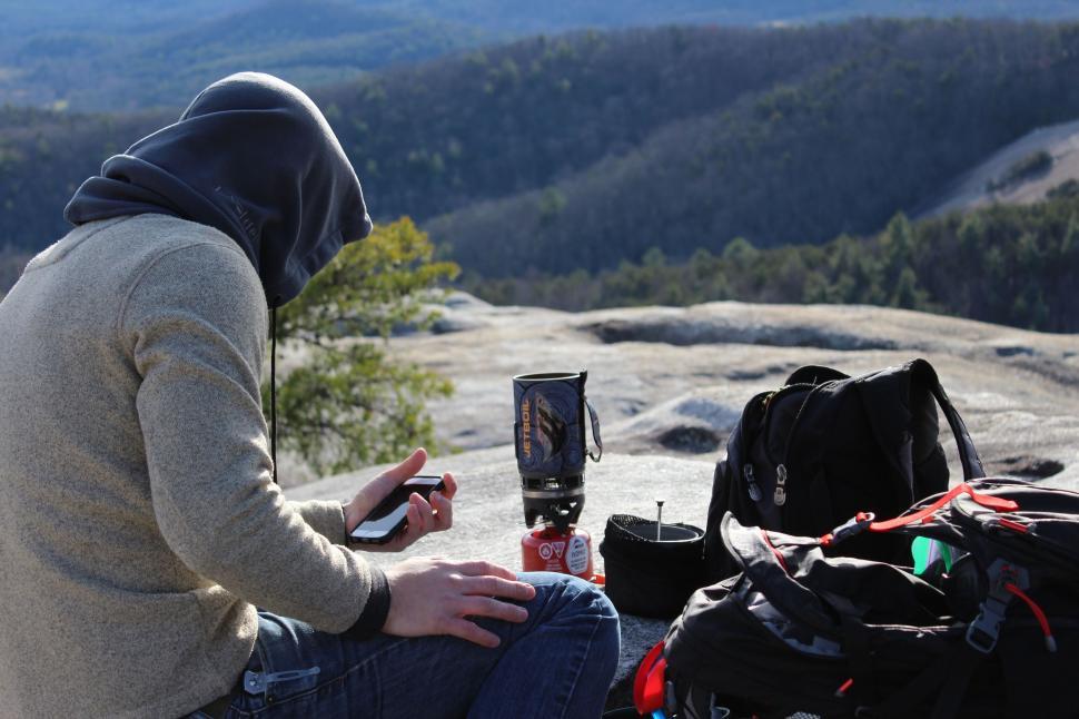 Free Image of Man Sitting on Top of a Mountain With Backpack 