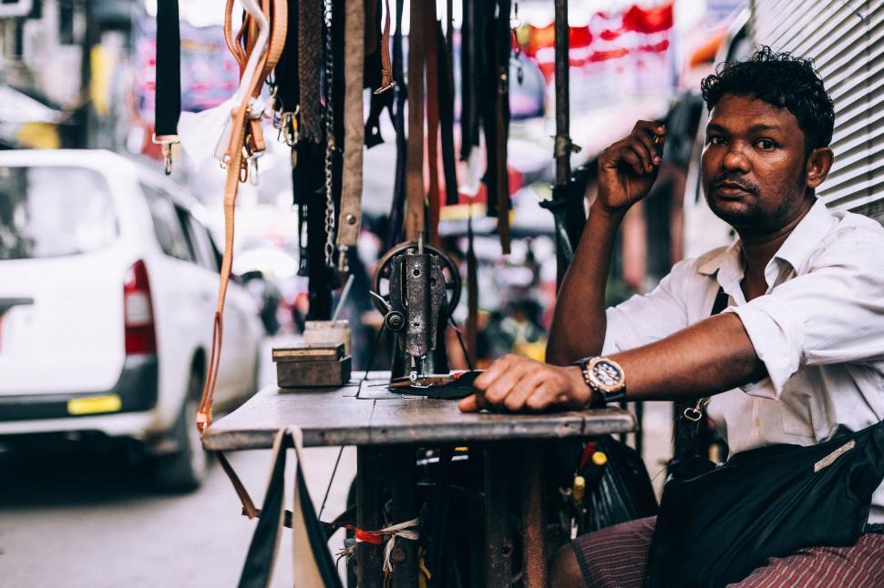 Free Image of Man Working on Sewing Machine at Table 