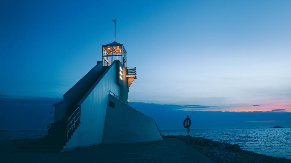 Free Image of Man Standing on Top of Building by Ocean 