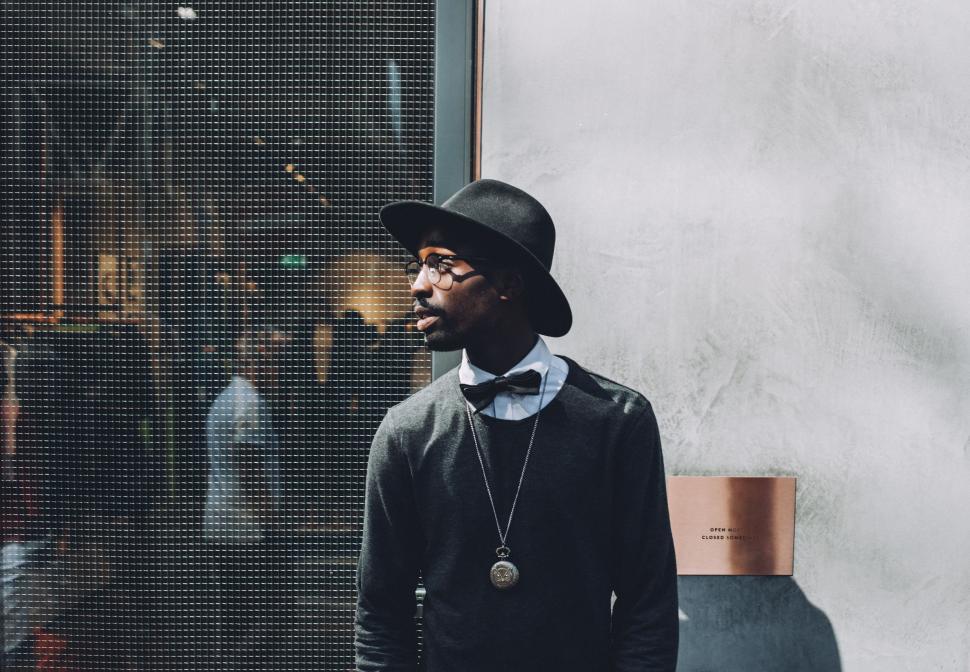 Free Image of Man Standing in Front of Window With Hat 