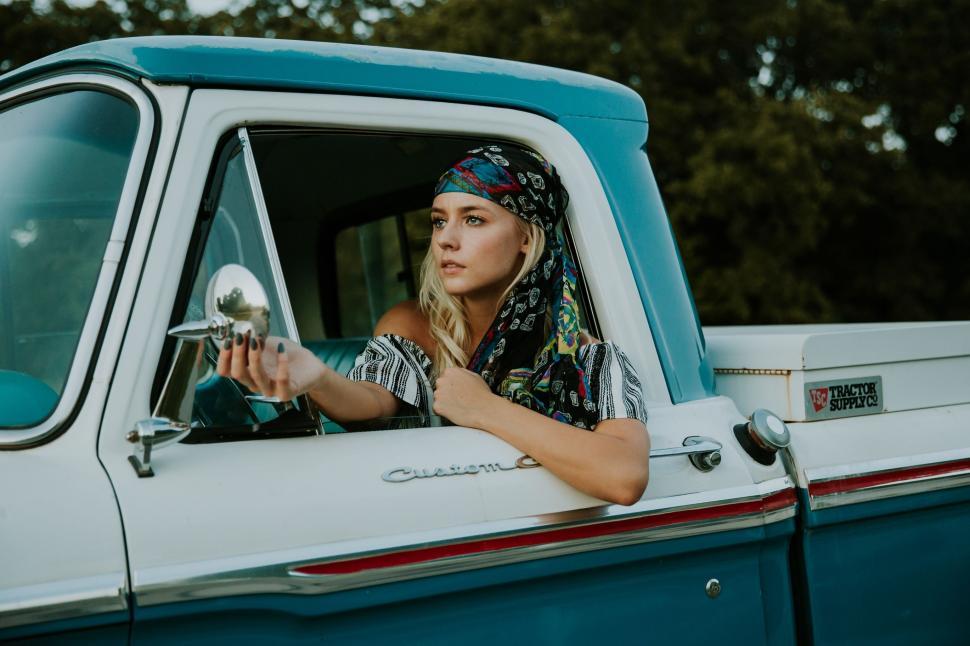 Free Image of Woman Sitting in the Back of a Truck 