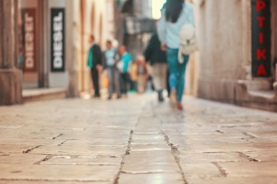 Free Image of Group of People Walking Down City Street Next to Tall Buildings 