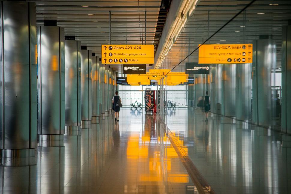 Free Image of Long Hallway With Yellow Signs on the Ceiling 