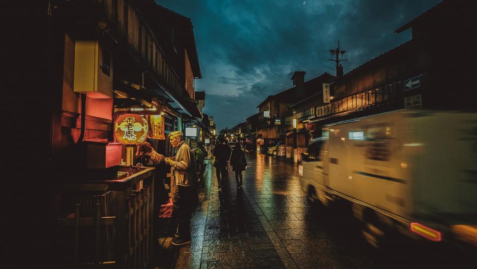 Free Image of Group of People Walking Down a City Street at Night 