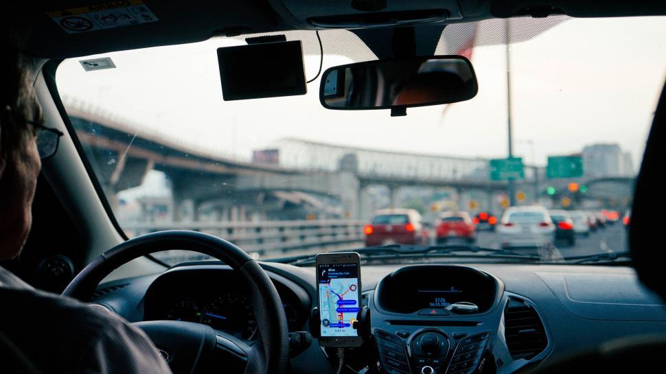 Free Image of Man Driving Car Holding Cell Phone 