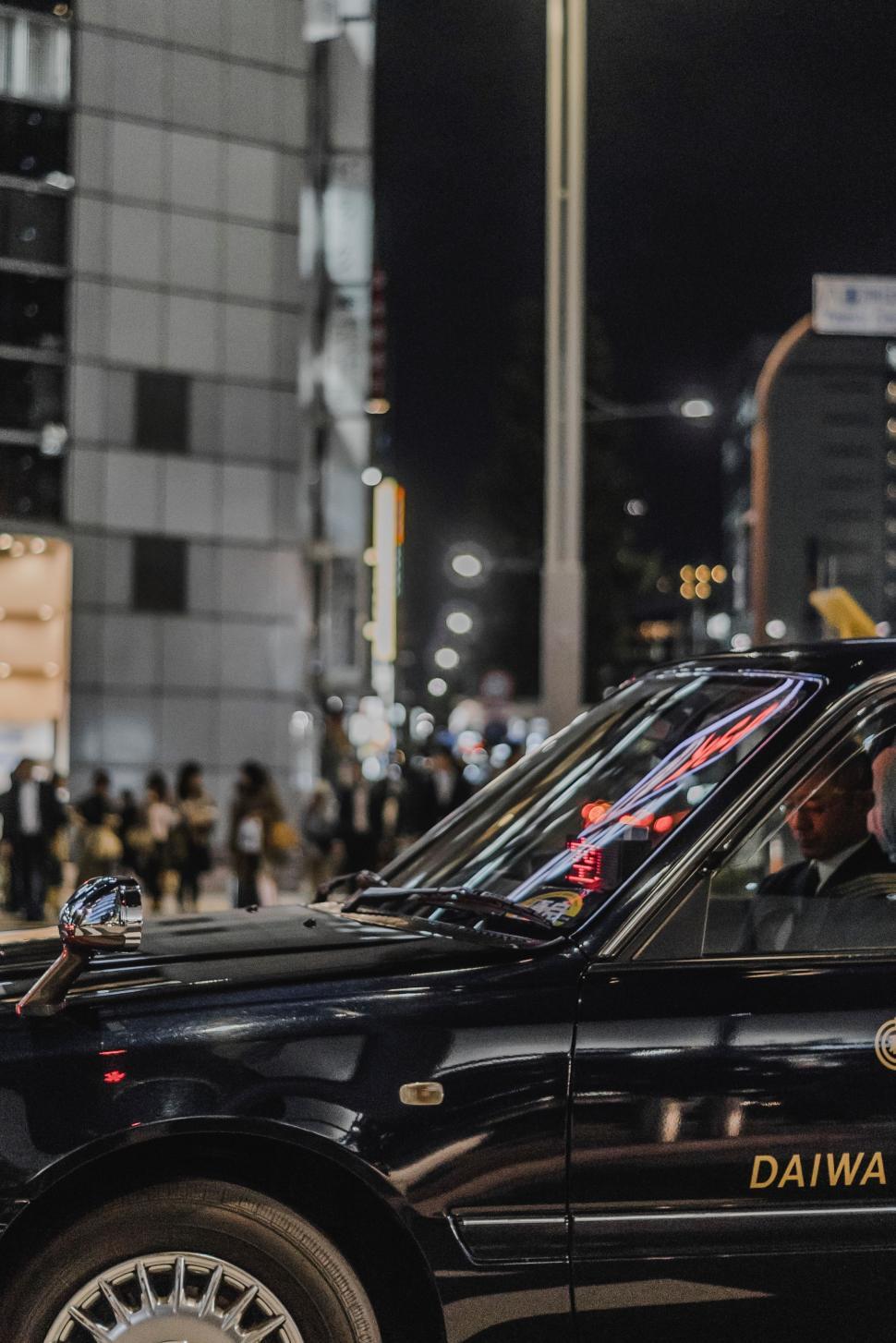 Free Image of Black Taxi Cab Driving Down Street at Night 